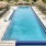 a swimming pool with a deck and chairs around it