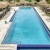 a swimming pool with a deck and chairs around it
