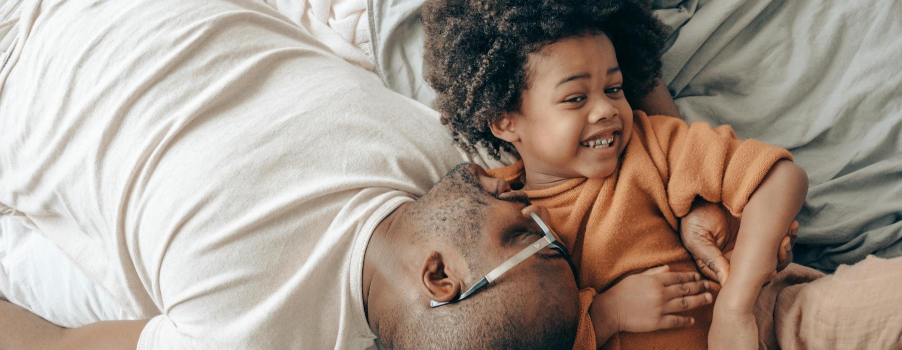 a person and a child lying in bed