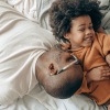 young father and son laying on bed