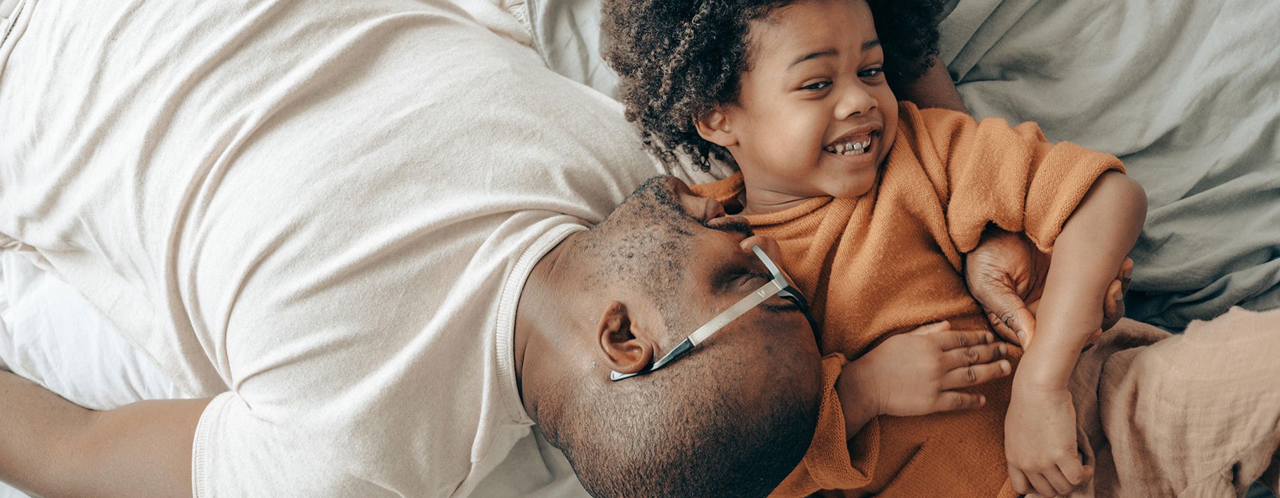 young father and son laying on bed